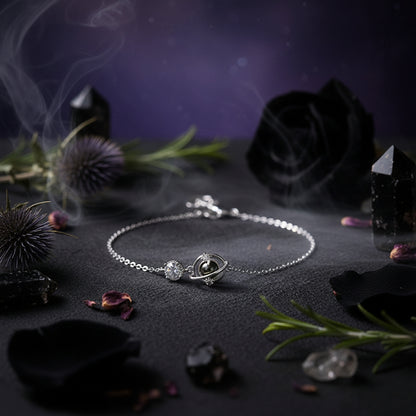 Silver necklace with a pendant held between fingers against a neutral background