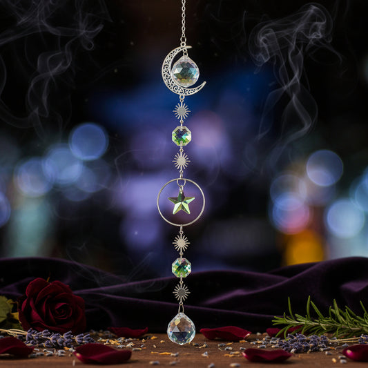 Decorative hanging ornament with celestial design on a wooden surface against a blurred colorful background