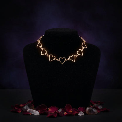 Rose gold heart-shaped necklace on a black mannequin against a gray background