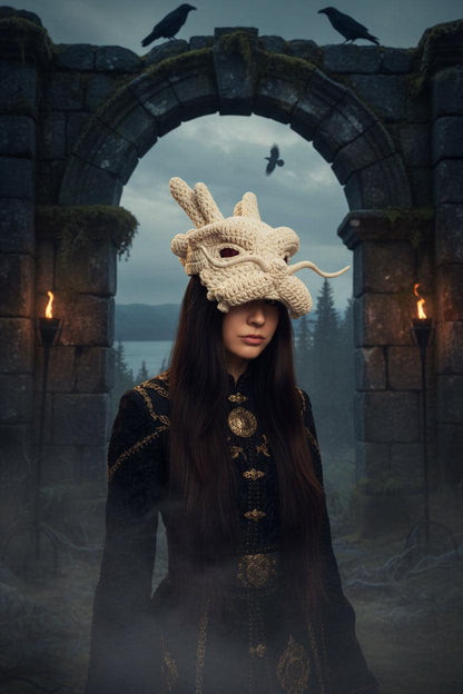 Person wearing a white dragon-shaped knitted hat against a plain background
