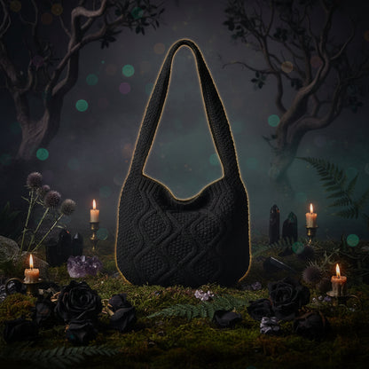 Black knitted bag on a white surface with a magazine underneath