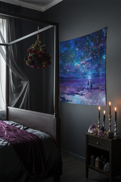 Tapestry with a cosmic scene of two people on a beach under a starry sky.