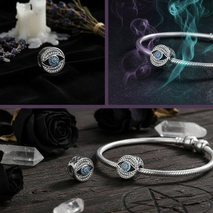 Silver eye-shaped charm with blue gemstones on a light blue background