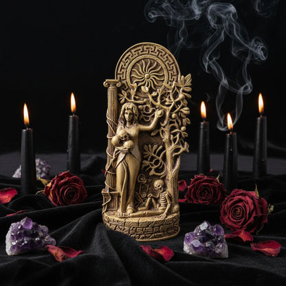 Decorative statue of a woman with a wheel and tree design on a stone surface.