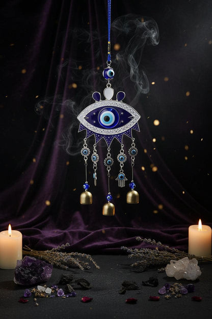 Decorative evil eye hanging with bells against a blue background