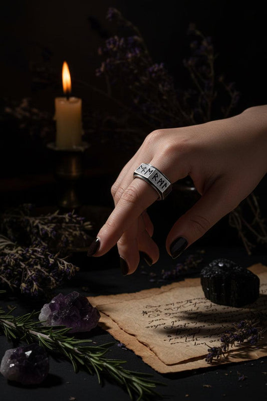 Silver ring with engraved symbols on a white background