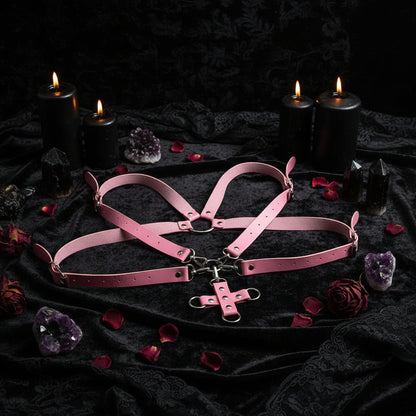 Pink leather harness with a central cross design on a white background