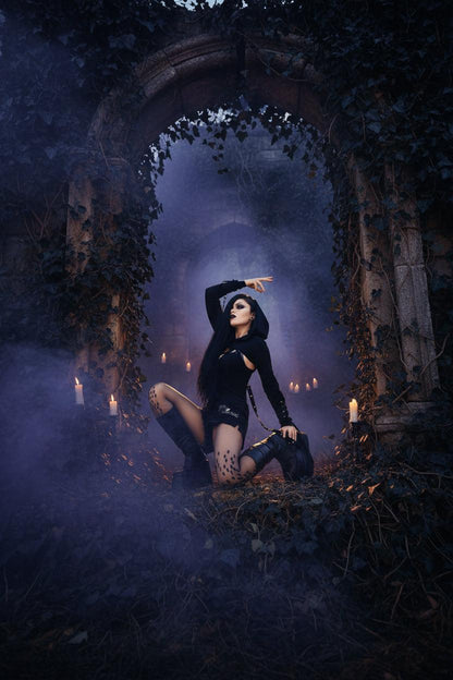 Gothic-style woman posing outdoors with a blurred background