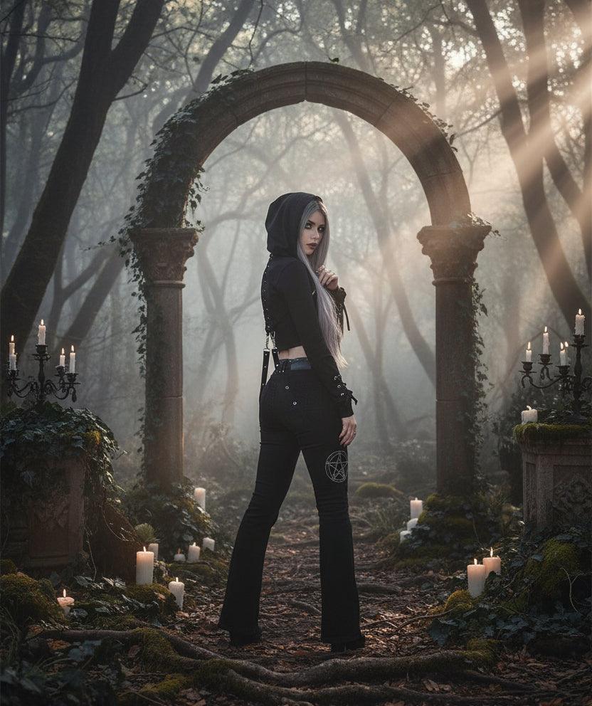 Person wearing a black outfit with a hood in a natural setting