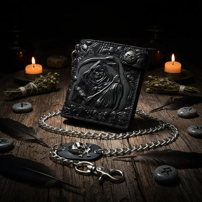 Black embossed wallet with chain held by a hand on a white background