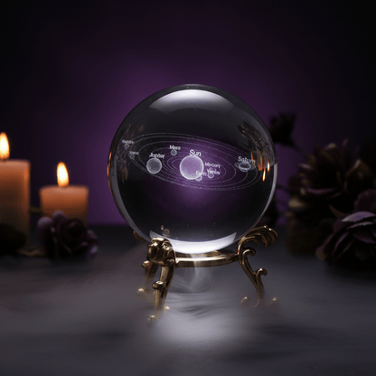 Clear crystal ball with solar system model on a decorative stand against a black background