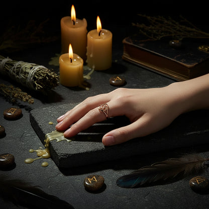 Hand wearing a gold ring with a geometric design on a white surface