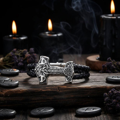 Bracelet with Thor's hammer design on a black braided cord against a dark background