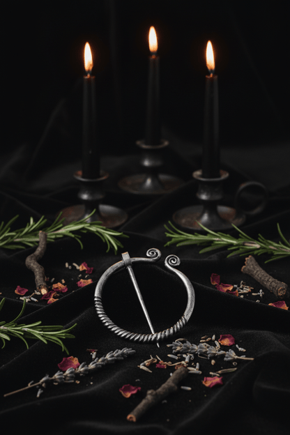 Silver brooch with intricate design on a wooden surface