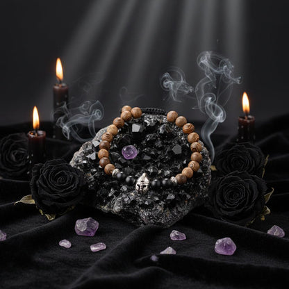 Wooden beaded bracelet with black stones and silver charm on a textured surface