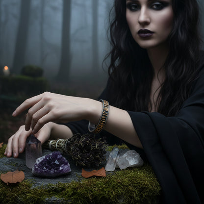 Runic bracelet on a textured stone surface with leaves