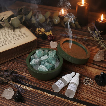 A round green container filled with green crystal stones, shown open on a wooden surface with two small dropper bottles beside it.