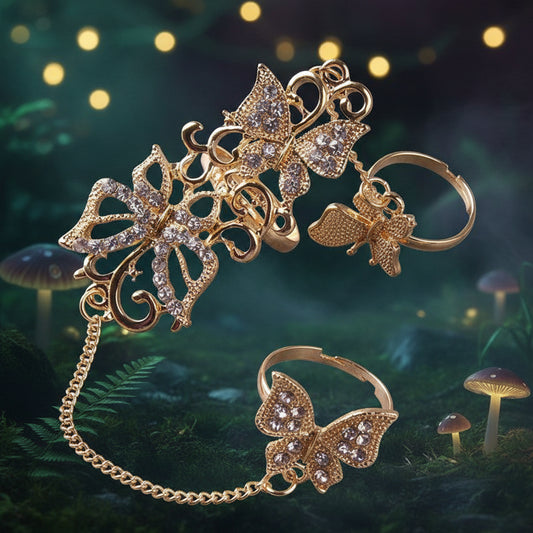 Gold-tone butterfly-themed jewelry set featuring a large ornate butterfly headband with dangling chain, a matching butterfly ring, and a small butterfly charm, all embellished with clear rhinestones on a white background.