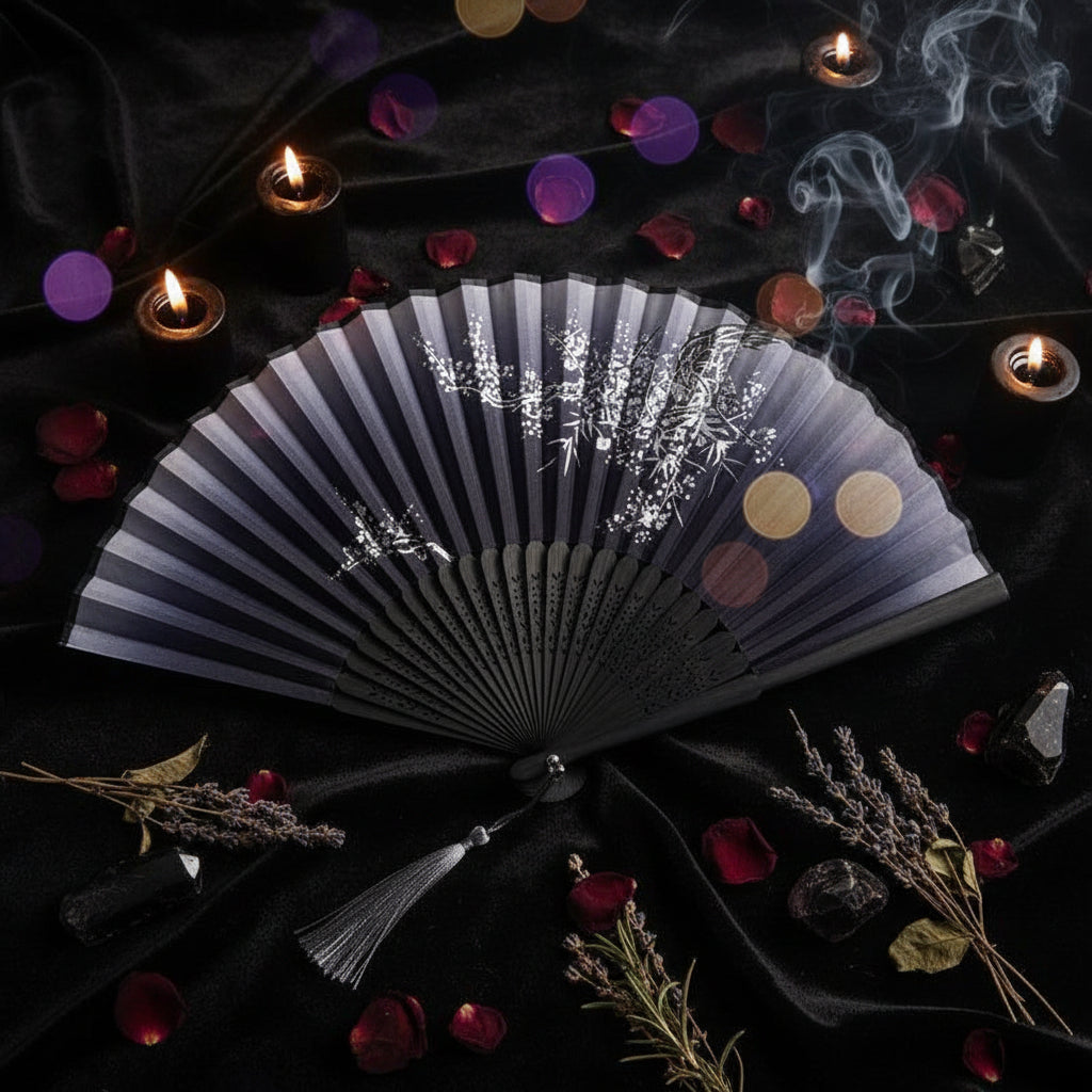 Black folding fan with floral design on a white background with pink flowers