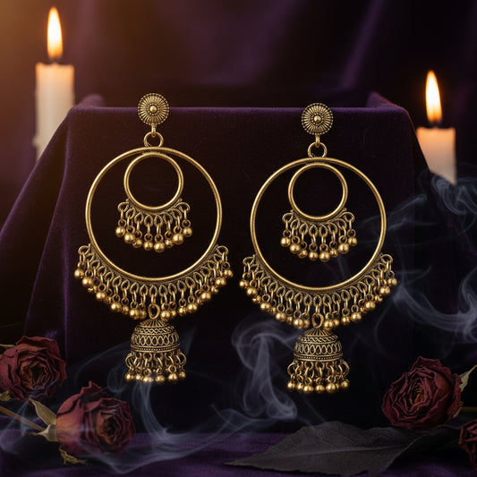 A pair of antique gold-toned dangle earrings with circular hoops, beaded fringe, and bell-shaped tassel charms on a plain white background.