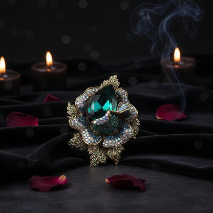 Decorative brooch with green gemstone on a white surface