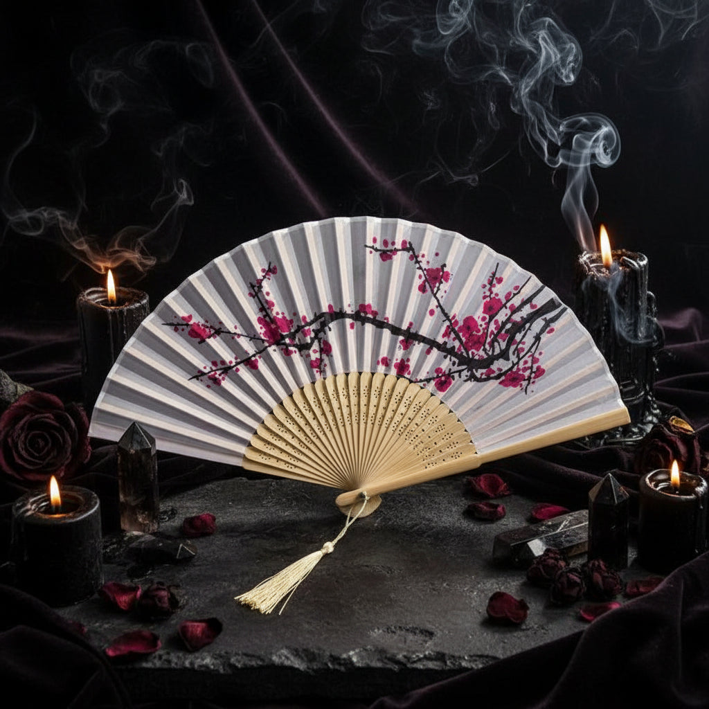 Traditional folding fan with cherry blossom design on a white background