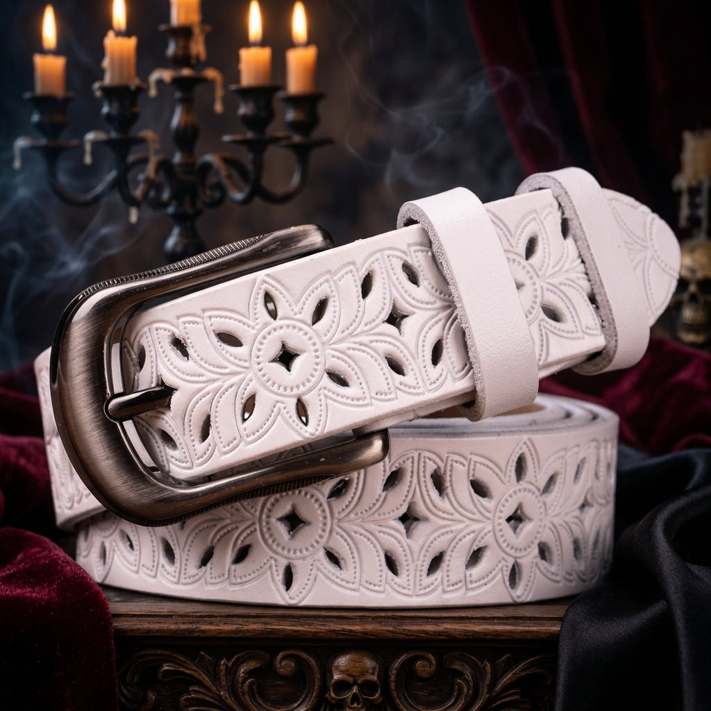 White leather belt with floral cut-out design and silver buckle on a beige background