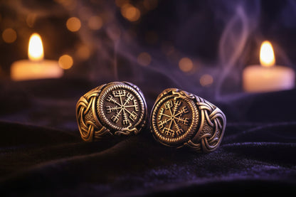 Two silver rings with intricate designs on a textured surface