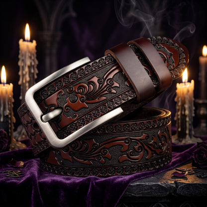 A dark brown tooled leather belt with a silver-tone buckle, coiled on a white background. The belt features intricate floral and scrollwork embossing.