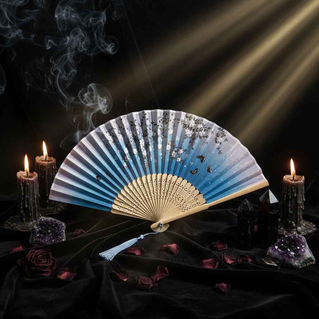 Traditional folding fan with artistic design on a light background with pink flowers.