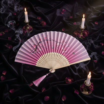 Pink hand fan with cherry blossom design on a light pink background