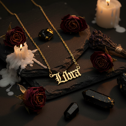 Gold 'Libra' necklace on a black background