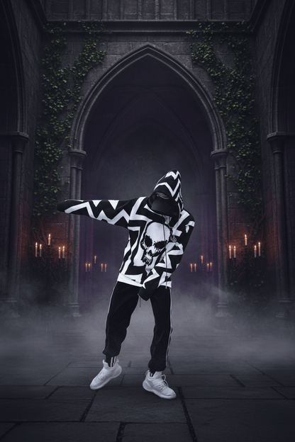A person wearing a black and white geometric patterned hoodie with a large white skull graphic on the front, paired with black jogger pants and white sneakers, posing in front of a concrete wall.