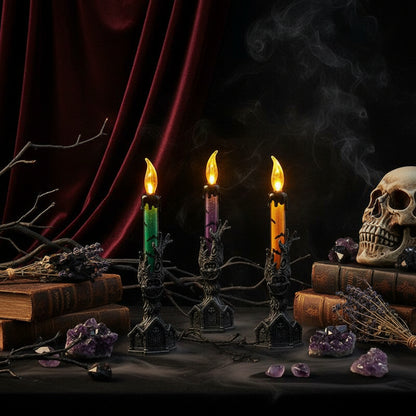 Three candle-like lights with dark, hand-shaped holders on a textured surface.