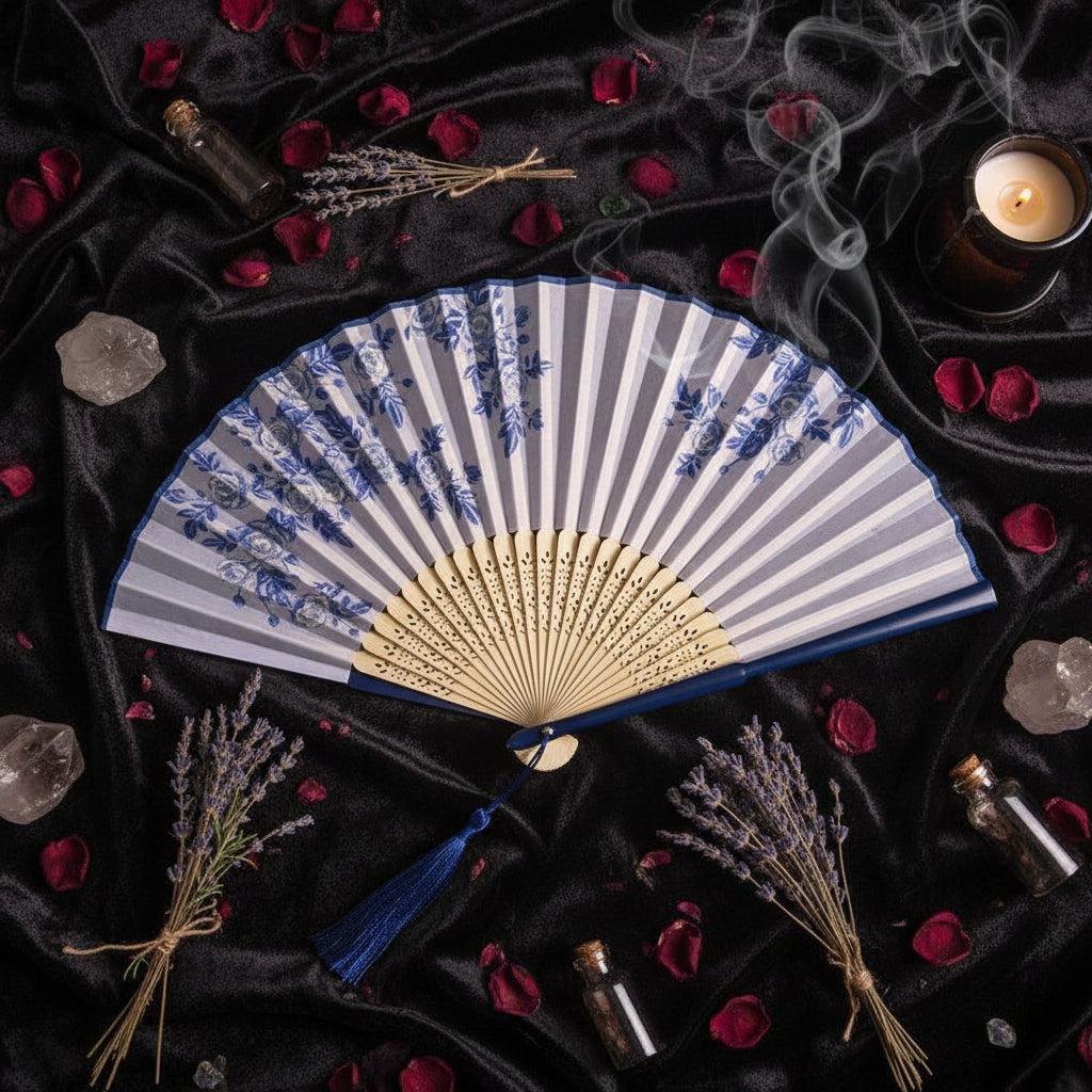 Traditional Chinese folding fan with blue floral patterns on a white background with pink flowers.