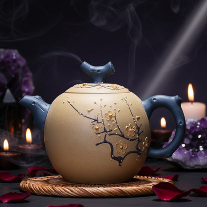 Ceramic teapot with blue handle and lid on a wooden surface, featuring floral design.