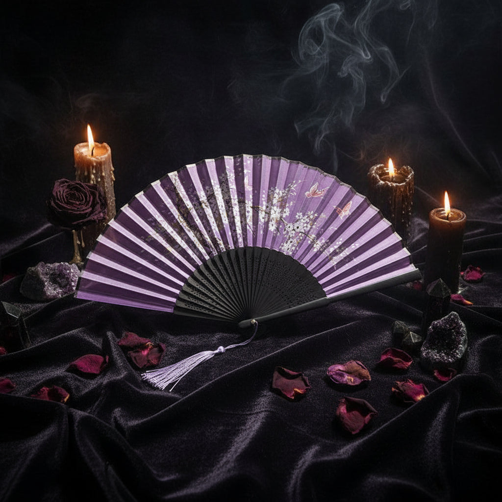 Purple and black fan with floral design on a white background with pink flowers.