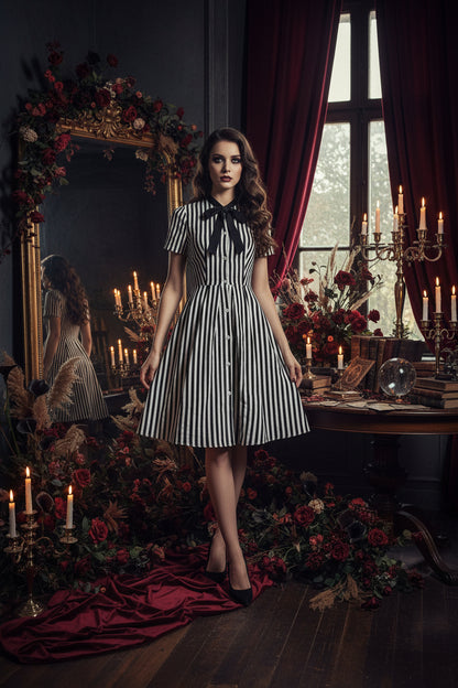 Black and white striped dress with a bow tie on a white background