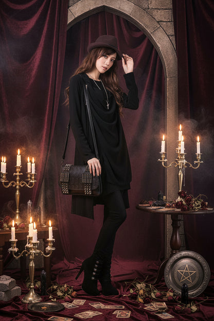 Woman wearing a black outfit with a hat and carrying a studded bag on a white background