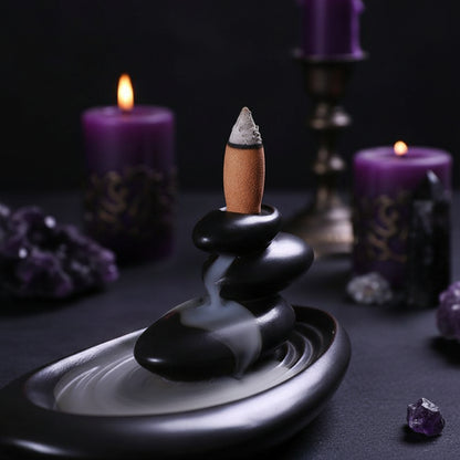 Incense burner with a smoking cigarette on a wooden surface