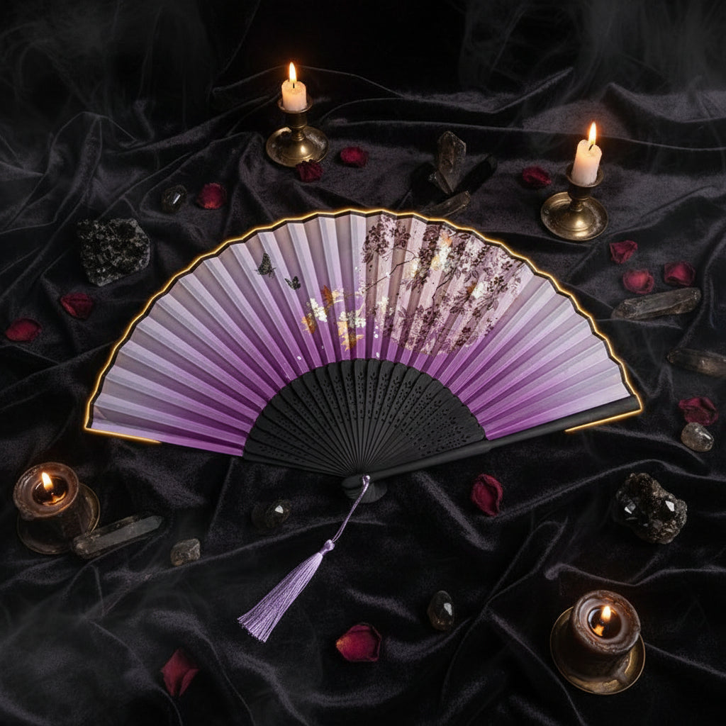 A traditional folding hand fan with a purple gradient and cherry blossom print, styled with pink flowers on a white background.