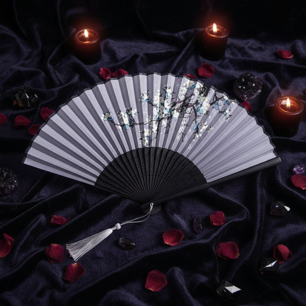 Black folding fan with floral design on a white background with pink flowers