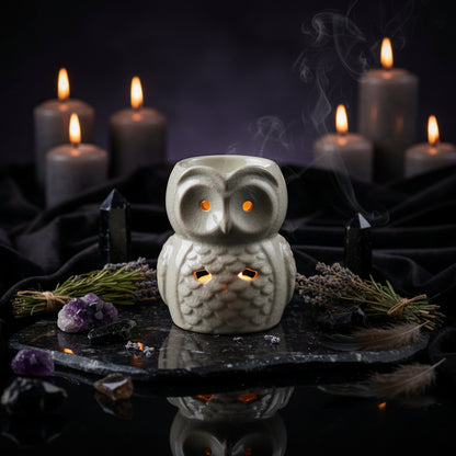 Ceramic owl-shaped candle holder on a wooden surface with a blurred background