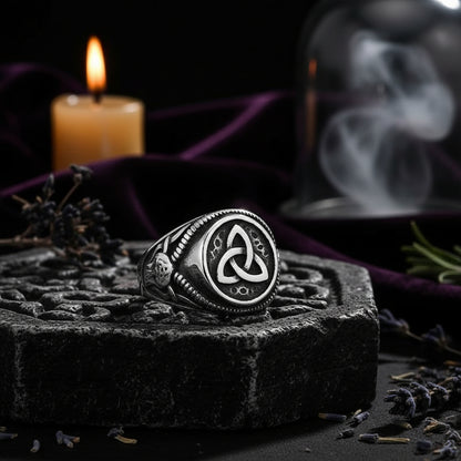 Silver ring with intricate design on a black background