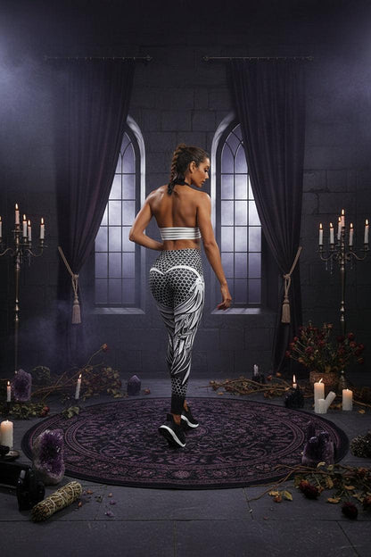 A woman modeling high-waisted athletic leggings with a black and white geometric pattern, shown from a rear three-quarter angle against a white studio background.