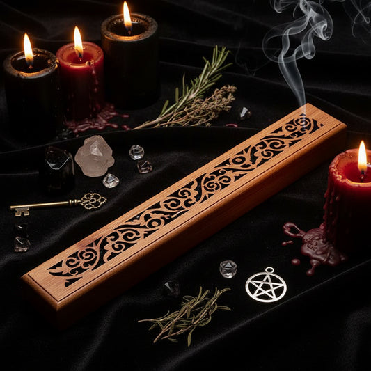 Wooden incense holder with intricate carvings on a dark wooden surface