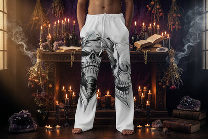 White sweatpants with skull design worn by a person on a plain background