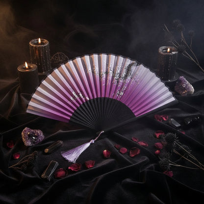 Pink and black folding fan with floral design on a white background