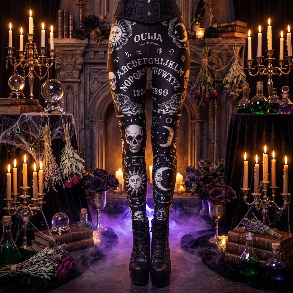 Black leggings with a white gothic horror print featuring skulls, a Ouija board, numbers, flames, and the word 'GOOO', shown on a model from the waist down wearing black platform boots against a white background.